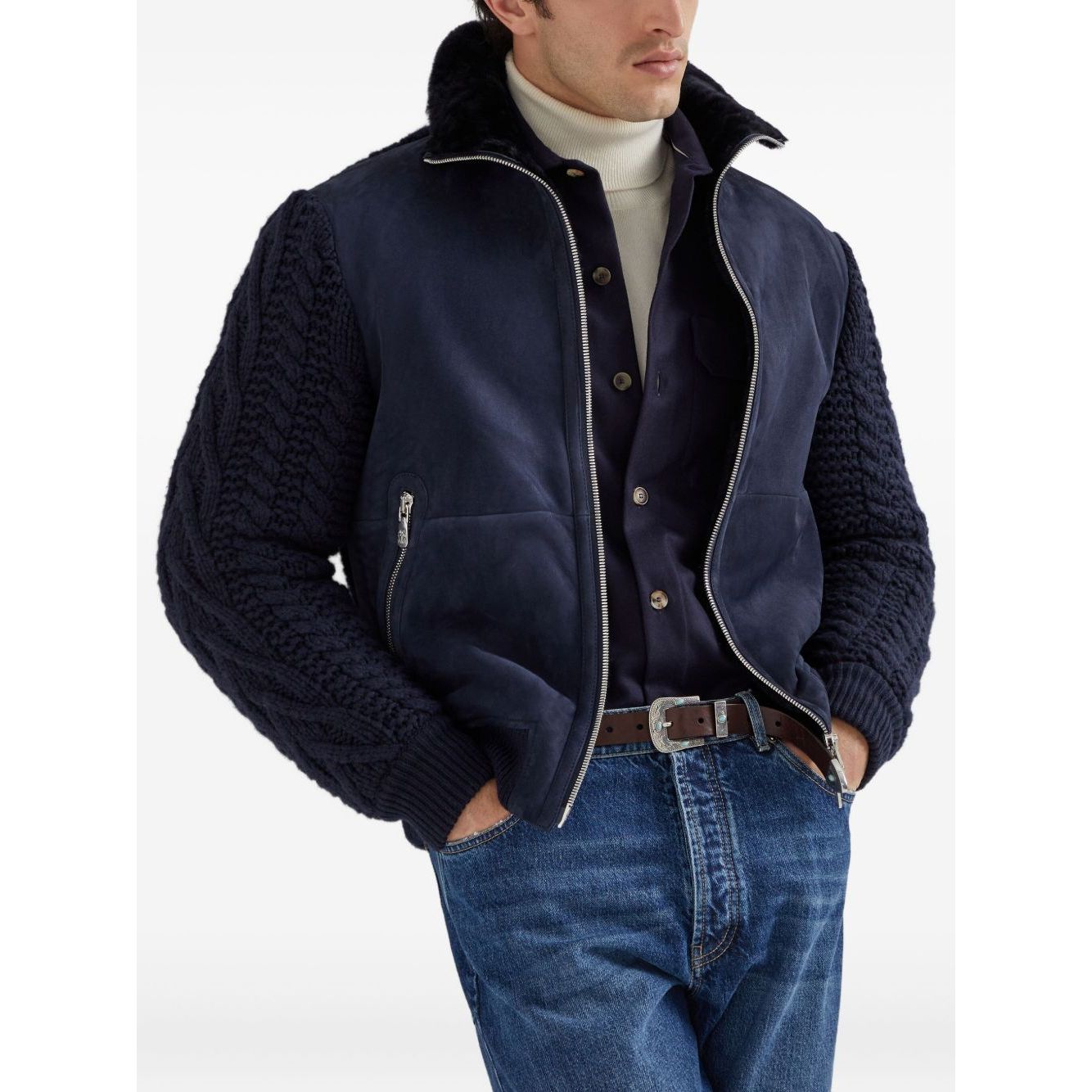 Man wearing Brunello Cucinelli Shirts Blue with a navy jacket, blue jeans, and a wool shirt featuring long sleeves and buttoned cuffs.