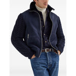 Man wearing Brunello Cucinelli Shirts Blue with a navy jacket, blue jeans, and a wool shirt featuring long sleeves and buttoned cuffs.