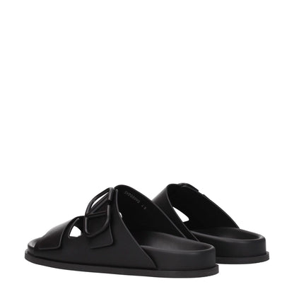 Valentino Garavani Black Leather Slippers with open toe design and front logo, featuring a low flat heel and rubber sole for casual style.