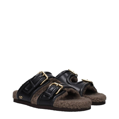 Valentino Garavani Black Leather Slippers with buckle closure and open toe design, featuring a rubber sole and casual style.