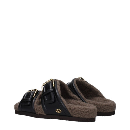 Valentino Garavani Black Leather Slippers with buckle closure and rubber sole, featuring open toe design for casual style.