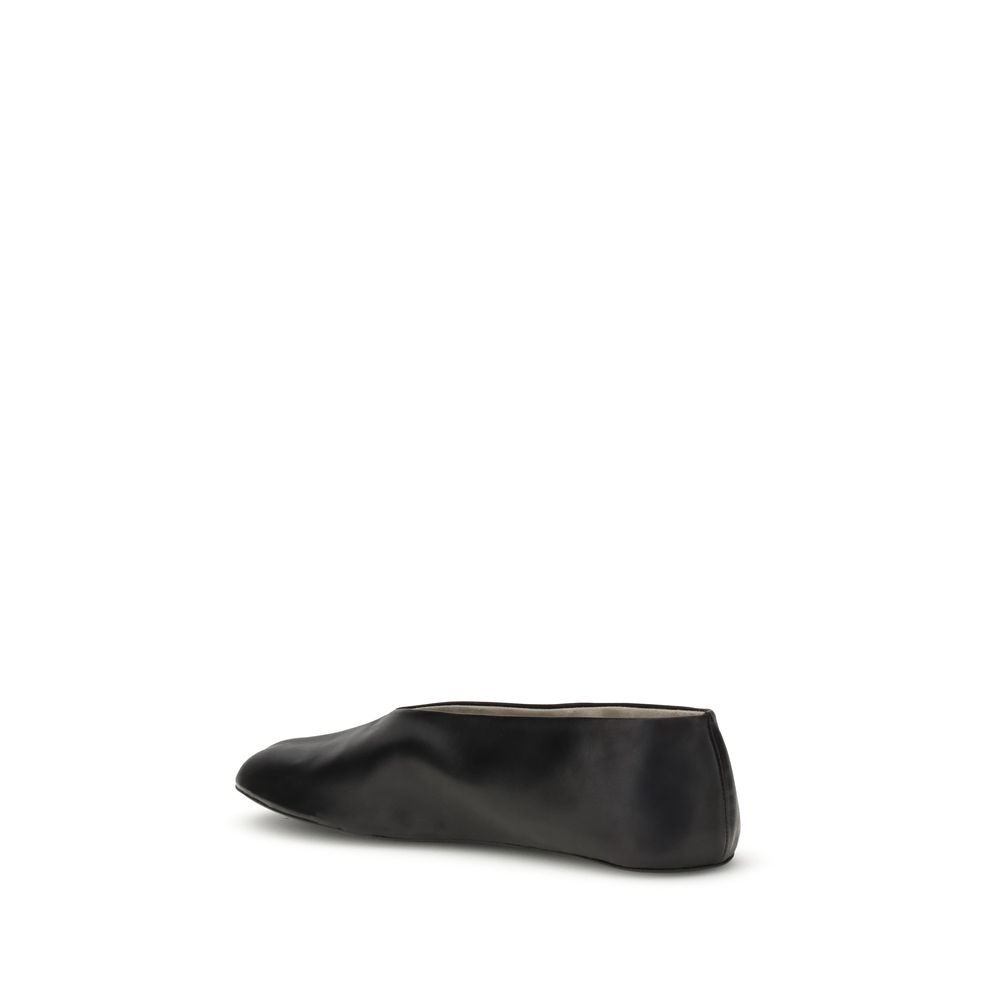 The Row Black Lamb Ovis Aries Aries Ballet Flats side view, showcasing sleek silhouette and tapered toe in black nappa leather.