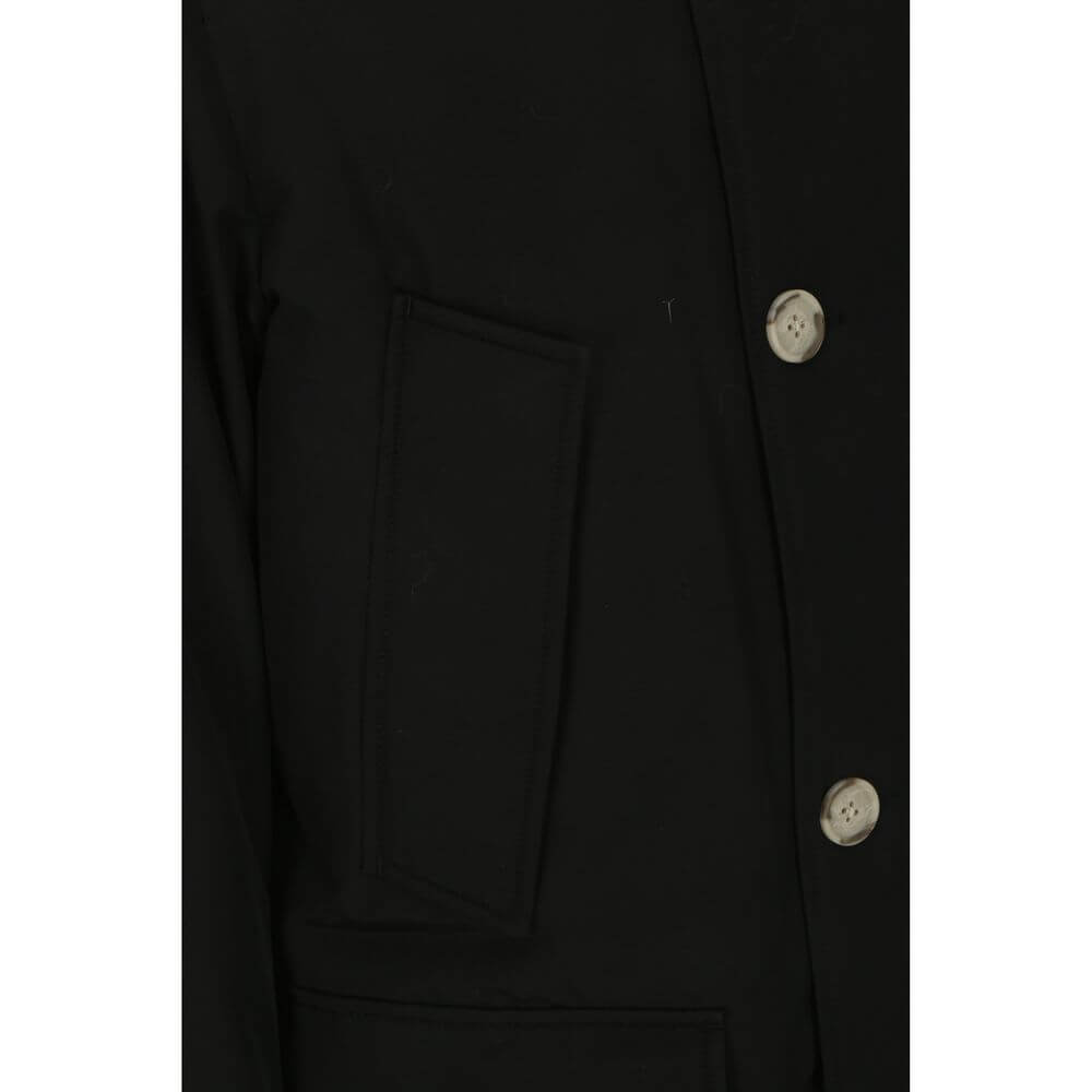 Close-up of Woolrich Black Cotton Parka with cista buttons and side patch pocket, highlighting the jacket's design detail.