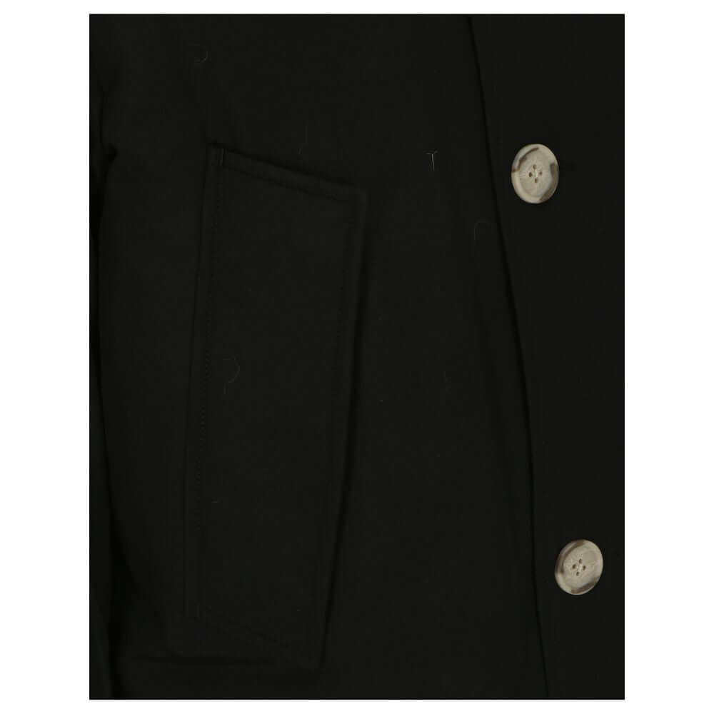 Close-up of Woolrich Black Cotton Parka showing side patch pocket and button details with ribbed cuffs, fur hood, and padded design.