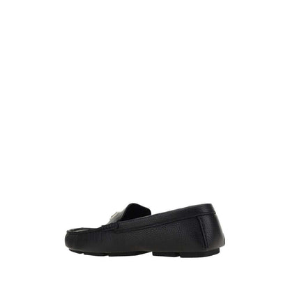 Dolce & Gabbana Black Rubber Slip-On Loafers side view showing non-slip sole and metal monogram plaque.