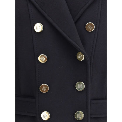 Close-up of Balmain Black Wool Coat with engraved gold buttons and wide lapels, showcasing sophisticated urban design.