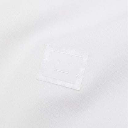 Close-up of face logo on Acne Studios White Cotton T-Shirt, 90% cotton, 10% elastane, unisex fit, made in Portugal.
