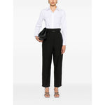 Woman wearing Brunello Cucinelli Shirts White with black trousers and holding a clutch bag, front view.