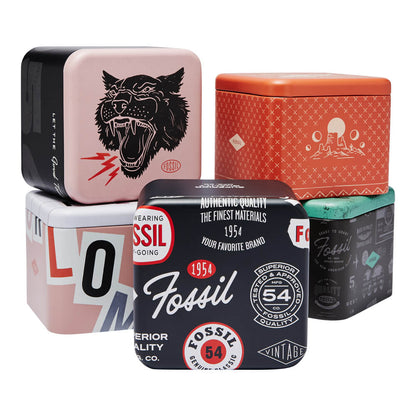 Stack of colorful Fossil metal boxes with vintage designs and logos, featuring wild animal and classic Fossil branding graphics.