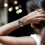 Woman wearing a FREDERIQUE CONSTANT MOD. FC-206MPBD1S6B watch with a stylish silver bracelet, featured in a chic and elegant setting.