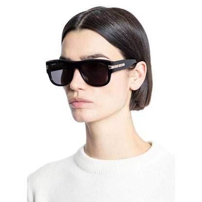 Gucci Black Acetate Sunglasses with shiny frame and UVA/UVB protection, worn by a person in a white sweater.