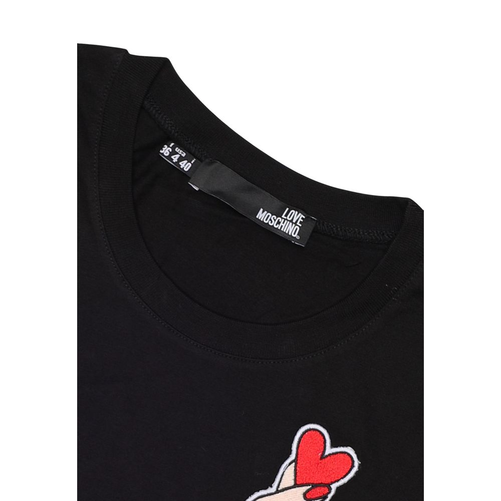 Close-up of Love Moschino Black Cotton T-Shirt with hand and red heart design on chest, stylish and comfortable women’s fashion.