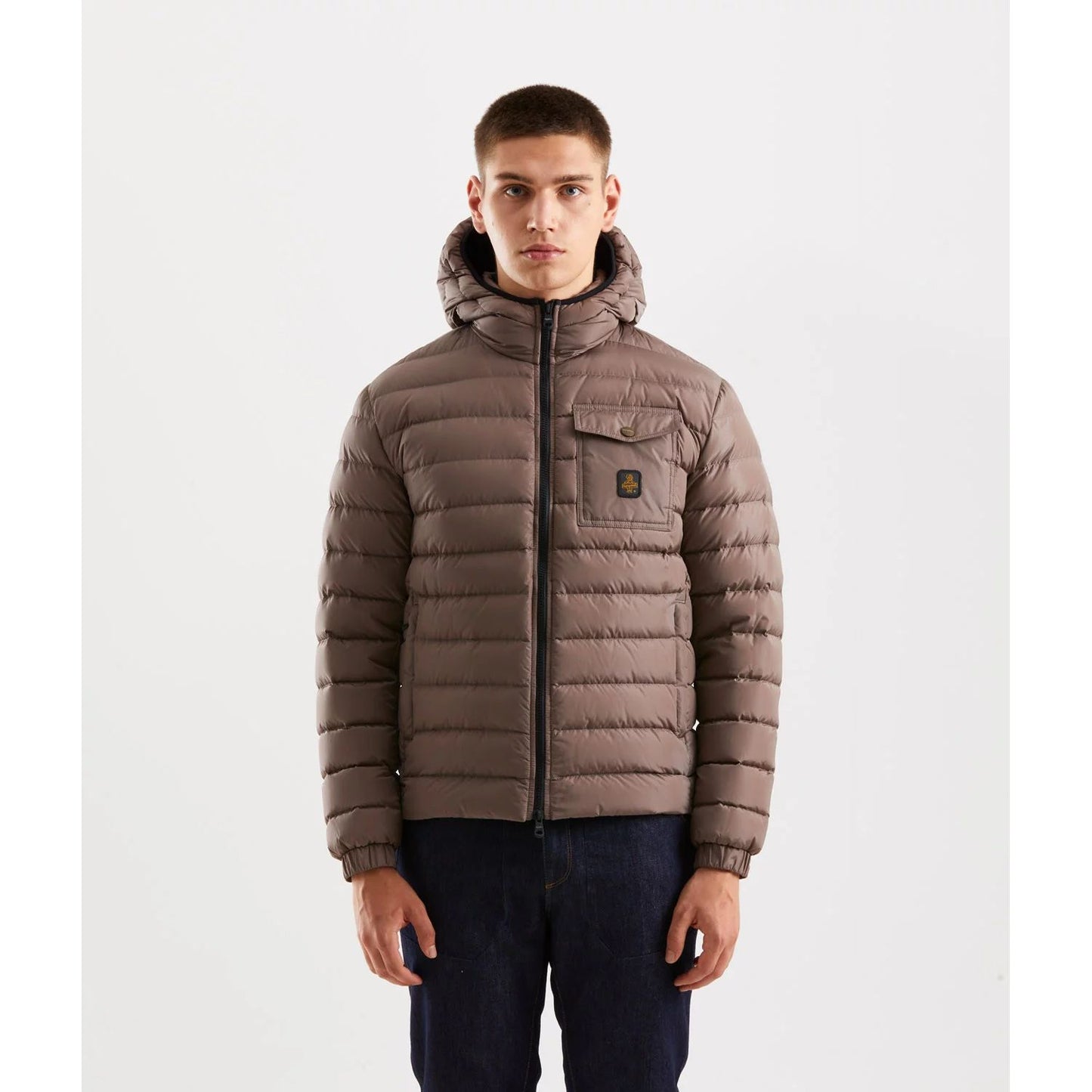 Man wearing Refrigiwear Beige Nylon Men Jacket with hood, chest pocket, and zip closure, ideal for urban winter style and warmth.