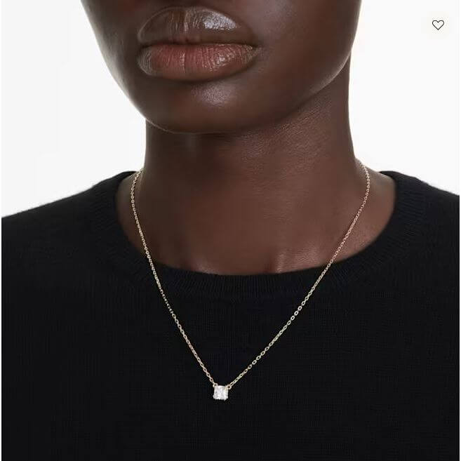Woman wearing elegant gold necklace with small pendant, minimal design.