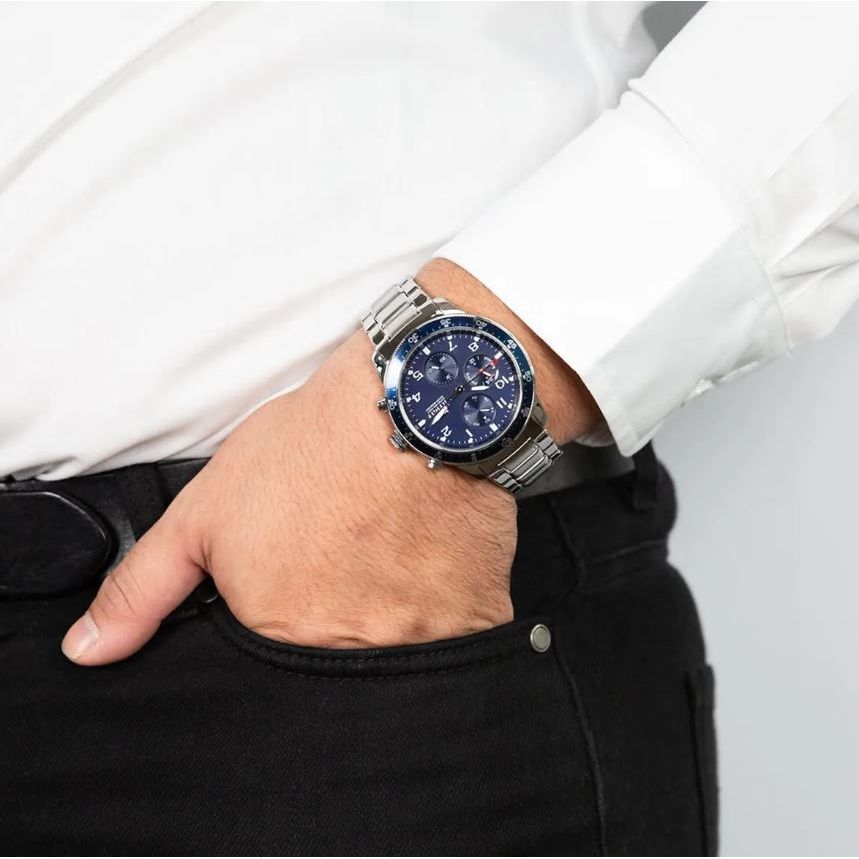 Gent wearing TOMMY HILFIGER Mod. 1791949 quartz analog watch, 44mm case, 5 ATM water resistant, mineral dial, official packaging