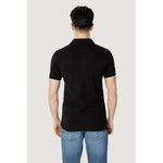 Back view of a model wearing Tommy Hilfiger Jeans Black Cotton Polo Shirt, short sleeves, slim-fit, classic collar.
