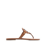 Brown leather Tory Burch Miller Sandals with laser-cut Double T logo, thong strap, and flat sole, perfect for a slip-on style.