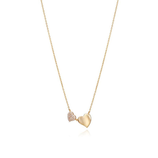 Gold heart necklace featuring two pendants on a delicate chain.