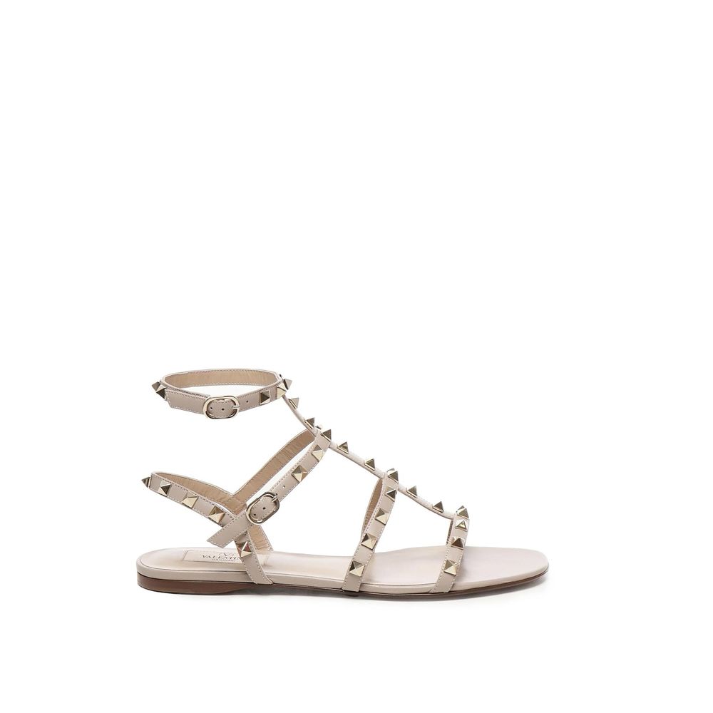 Valentino Garavani Beige Calfskin Sandals with gold-tone rockstud embellishments and ankle buckle fastening on leather sole.